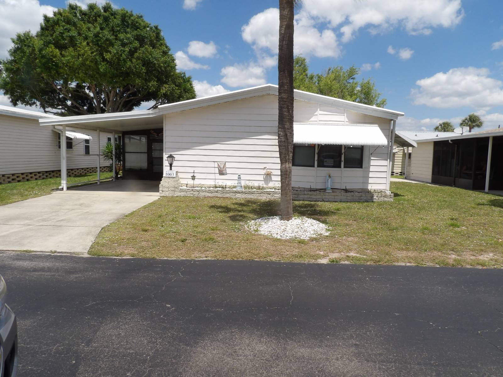What a view of the pond from the living room, kitchen, or lanai. This 2 BR 2 BA 1092 SQ FT home has an 11.5 X 17 FL room and a 14.5 X 15 screen lanai with cobblestone flooring providing 1505 SQ FT of living space for relaxing and entertaining. This home has too many features to list, but outside has aluminum shutters, a 2020 AC, a rubber roof, an irrigation system for watering, bay windows in the living room, an 11.5 X 20.5 carport, and a 7 X 10 shed. Inside, there is an L-shaped kitchen with a serving island, opening into the dining room with a built-in hutch, a larger living room with newer furniture and curtains, pecan wood flooring, a kitchen with newer appliances and disposal, and a master with a walk-in closet and a step-in shower, also there is a laundry area. You have to see to appreciate all this home has to offer. Call today for an appointment.