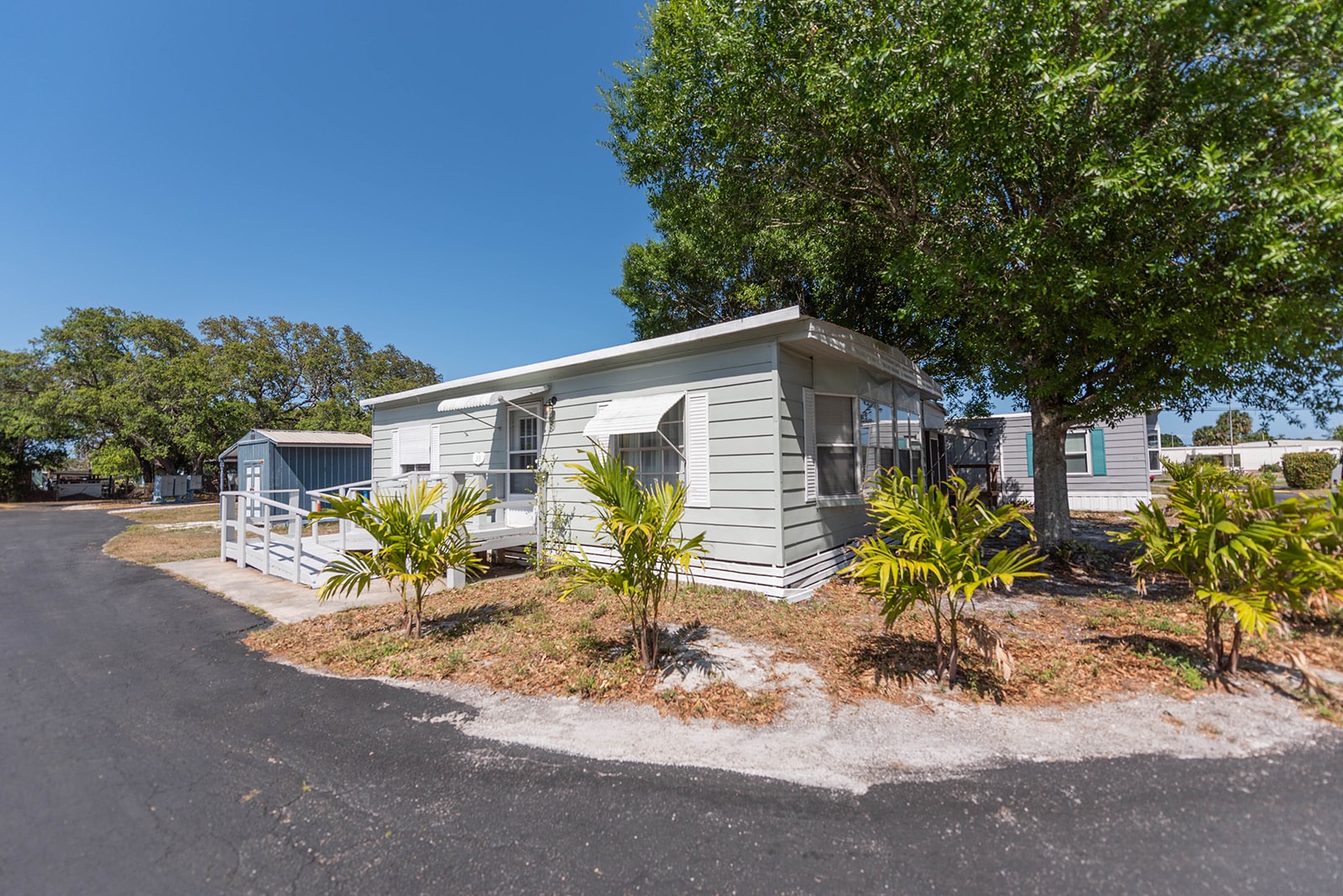 Welcome to your charming new home in a friendly 55+ community! This inviting corner lot 2-bedroom, 1.5-bathroom residence offers comfort, convenience, and thoughtful features throughout. Step inside and enjoy no carpet-easy-to-maintain flooring runs throughout the home, perfect for both pets and practicality.  A wooden ramp leads up to the front entrance, offering easy access for all. Inside, you'll find a bright, open layout ideal for relaxing or entertaining. The screened-in back patio provides a peaceful retreat to enjoy your morning coffee or evening breeze without the bugs.  Pet-friendly and located in a quiet, well-maintained park, this home combines independence with a sense of community. Don't miss your chance on this home with lot rent only being $575 per month for comfortable living in a welcoming 55+ neighborhood.