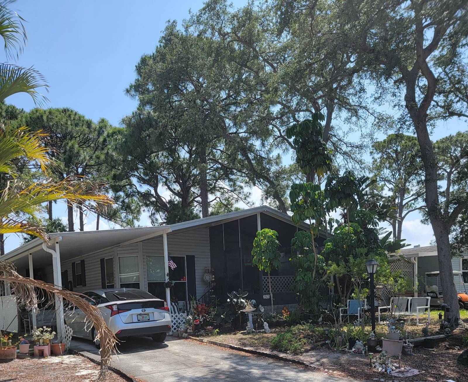 This property offers a spacious nearly 1,200 sq ft large master bedroom ensuite with two large closets and a big, bathroom with a walk-in shower with a dressing/makeup area. The home features an inviting eat-in kitchen with a bay window, perfect area for coffee and viewing the birds, squirrels or people walking the park. Additional highlights include a screened porch, mail box in front no going to the office for mail pick up, covered carport, long drive 3 cars and two sheds-one with a large opening for easy access ideal for lawn equipment,  tools, even a golf cart, or and bikes   Located in a peaceful park close to the Indian River, eateries, bus line, banking,  shopping and college minutes away This home presents a great opportunity for buyers willing to do some updates. The property is priced competitively for a quick sale and comes with essential appliances-stove, refrigerator, washer, and dryer. The floors are all solid, and the metal roof is newer, adding value.  Since the home is full of &quot;items&quot; (likely meaning furnishings or items), it can be sold as-is with the items included, or some items can be removed before closing.   For more details or to schedule a showing, contact Debora today! This home is considered  retirement haven although a lot of people in this park work full time. With 80/20 rule Manager will accept late 40's.